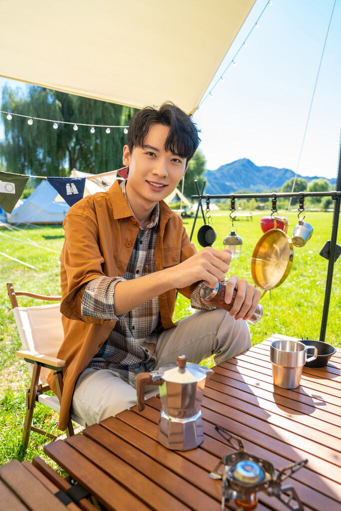 男孩坐天幕下研磨咖啡图片