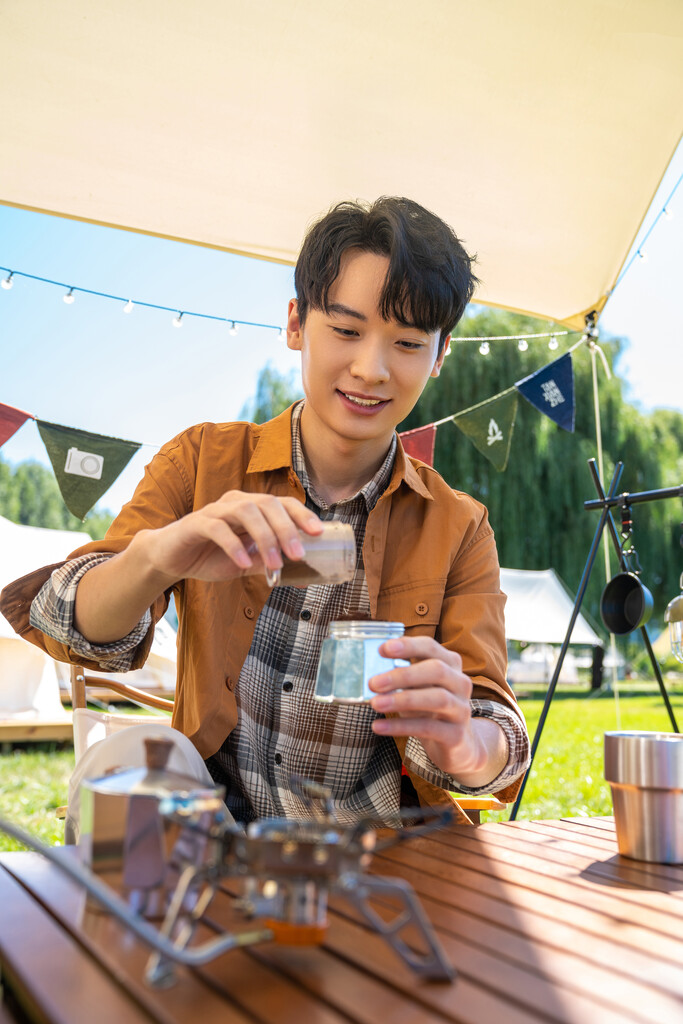 男孩坐天幕下煮咖啡