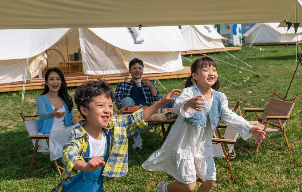 一家人在露营地天幕下玩耍