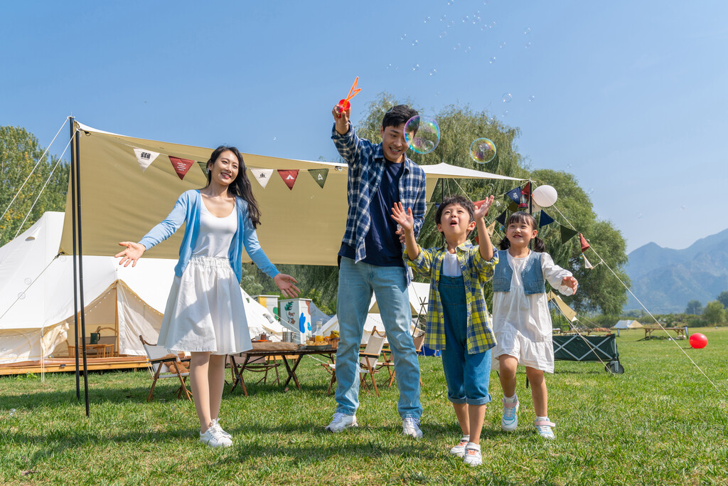 一家人在露营地天幕下玩耍