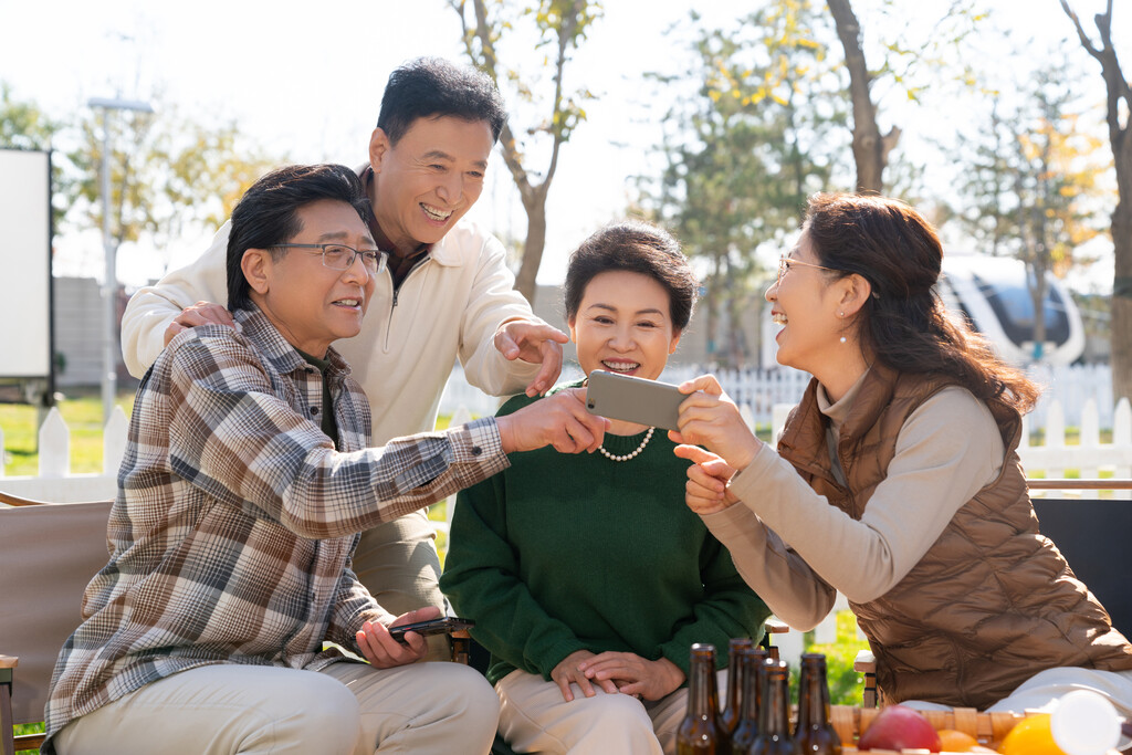 一群中老年人在房车露营地看手机视频图片