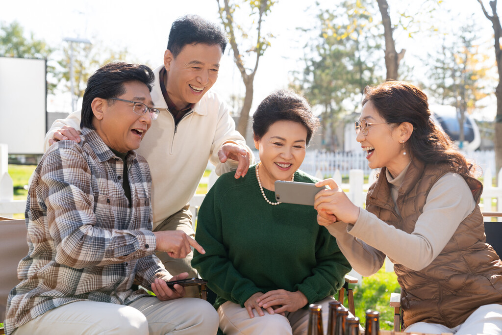 一群中老年人在房车露营地看手机视频图片