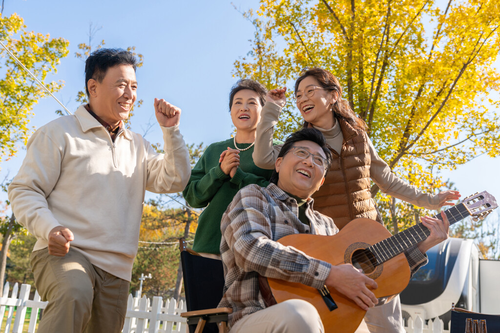 一群中老年人在房车露营地弹吉他唱歌图片