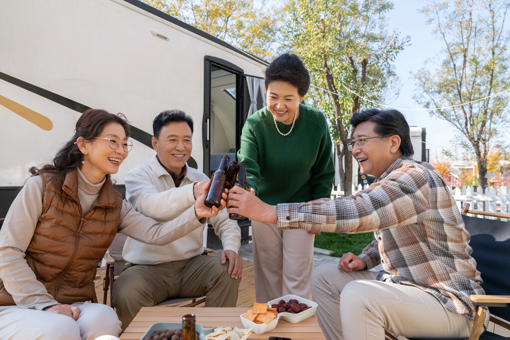 一群中老年人坐在房车露营地喝啤酒聊天图片