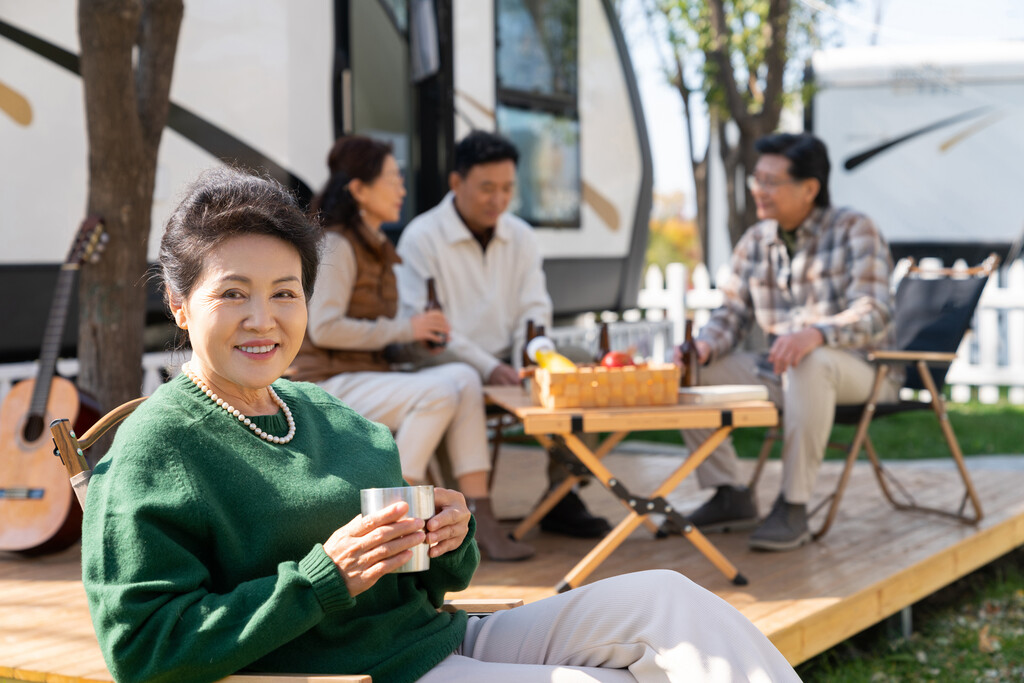 一个老年女人坐在房车露营地喝咖啡图片