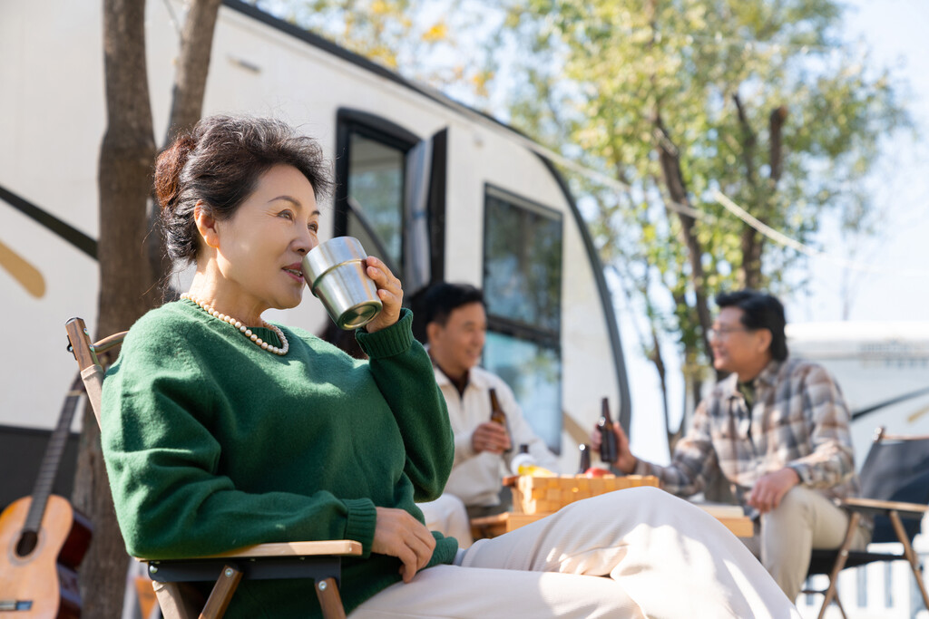 一个老年女人坐在房车露营地喝咖啡图片