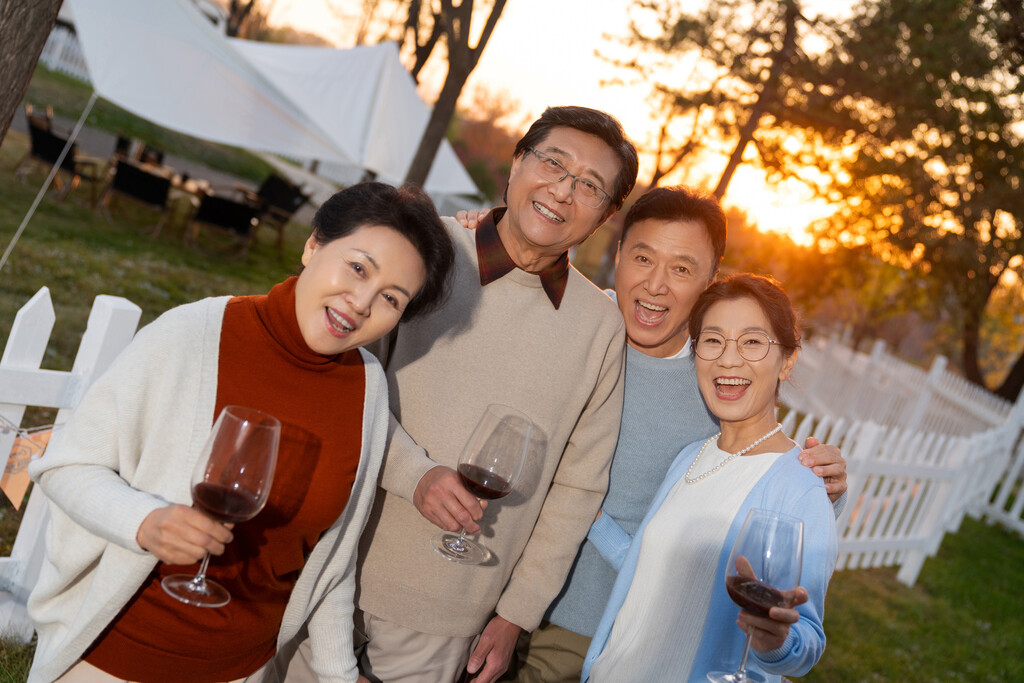 夕阳下中老年朋友在庭院里聚会喝酒聊天图片