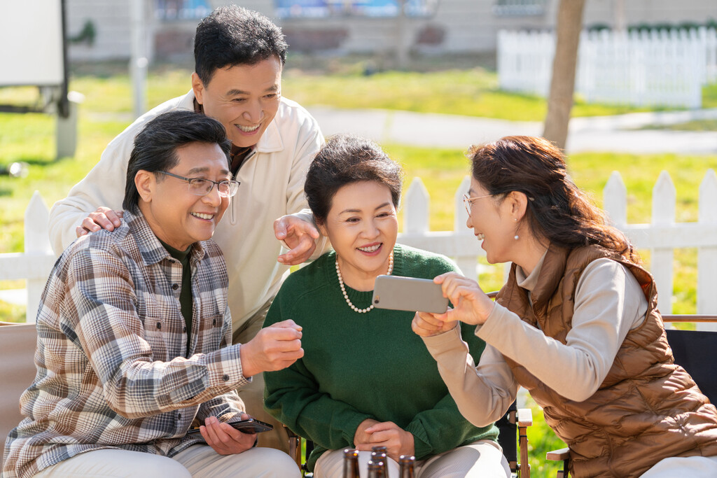 一群中老年人在房车露营地看手机视频图片