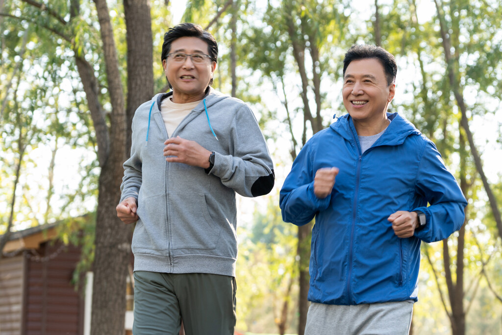 两戴运动手表的中老年男人在树林里跑步健身图片