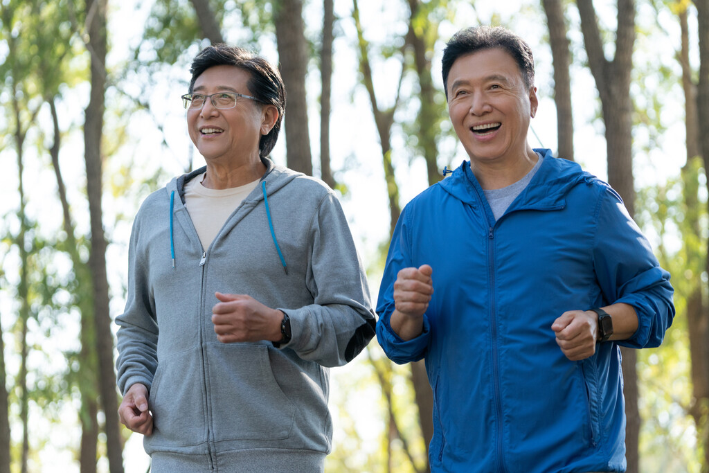 两个戴运动手表的中老年男人在树林跑步健身图片