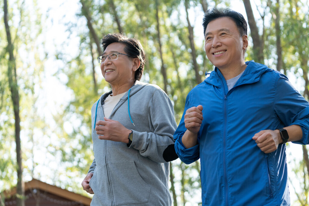 两个戴运动手表的中老年男人在树林跑步健身图片