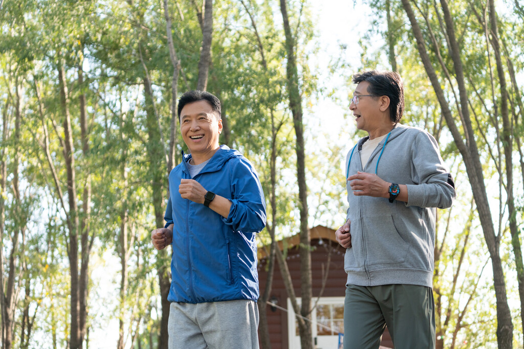 两戴运动手表的中老年男人在树林里跑步健身图片