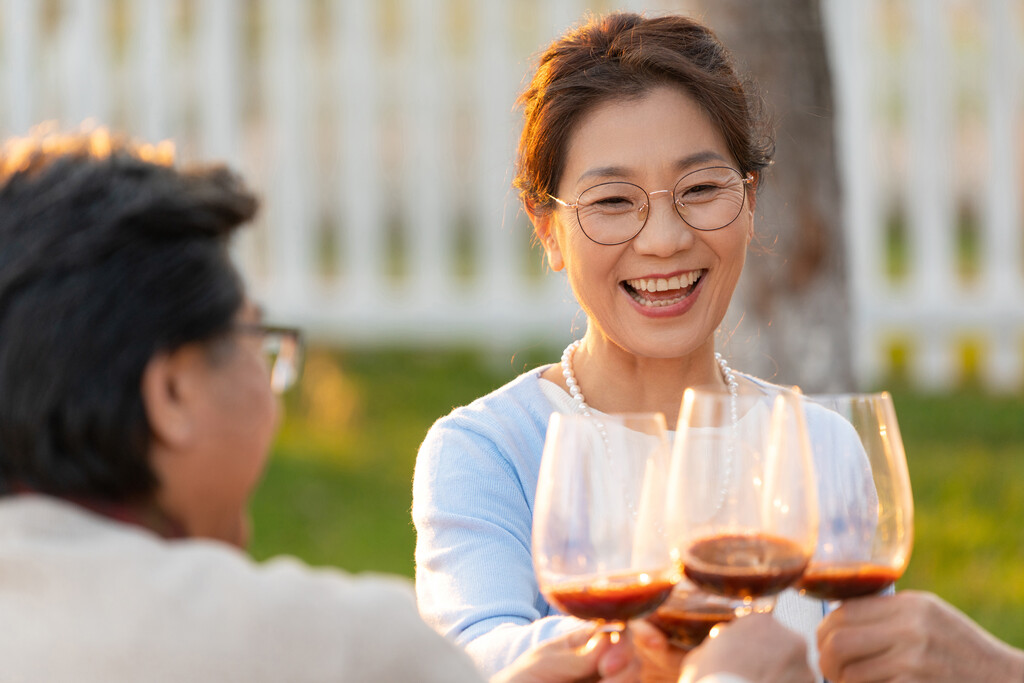 夕阳下中老年朋友在庭院里聚会喝酒聊天图片